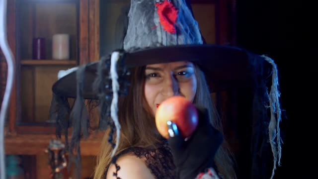 Halloween-Hexe-mit-Hut-hält-einen-giftigen-Apfel.