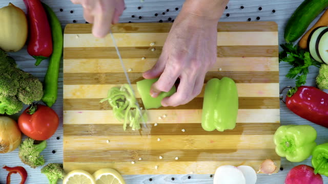 Hombre-es-cortar-hortalizas-en-la-cocina,-cortar-pimiento-verde-fresco