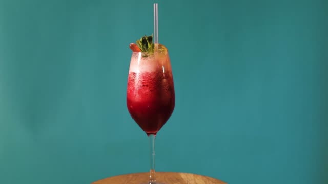 Rot-auf-blauem-Hintergrund,-cocktail-cocktail-dreht-auf-blauem-Hintergrund,-alkoholischen-Cocktail-auf-blauem-Hintergrund