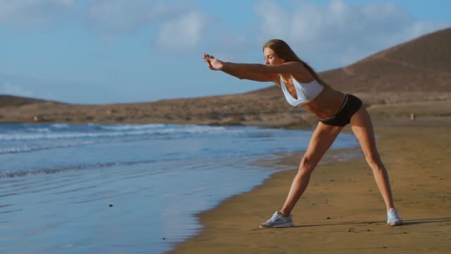 Frau,-dehnen,-Beine-und-Oberschenkel-stehen-nach-vorne-beugen-Yoga-Stretch-Pose-am-Strand-zu-tun.-Fitness-Frau-entspannen-und-Sport-und-Yoga-zu-praktizieren.
