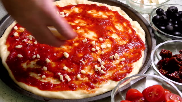Geriebener-Mozzarella-Käse-verlegen-auf-Pizza-Belag.
