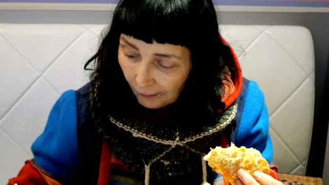 Woman-in-bright-clothes-eats-pizza-and-drinks-coffee.