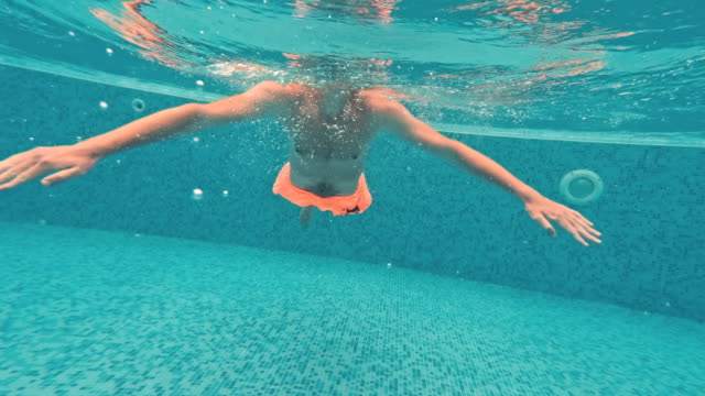Young-guy-swims-underwater-in-a-swimming-pool