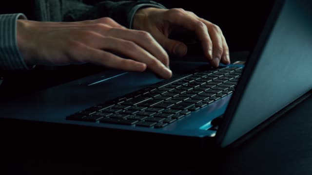Man's-hands-typing-text-on-a-laptop.-Late-evening.-Dark-office.-Slow-motion
