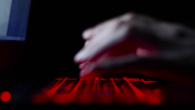 Hacker-Mädchen-Hand-tippen-auf-Tastatur-mit-roter-Hintergrundbeleuchtung