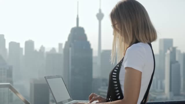 Freelancer-using-laptop-on-modern-city-background.