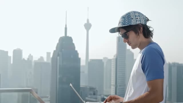 Freelancer-using-laptop-on-modern-city-background.