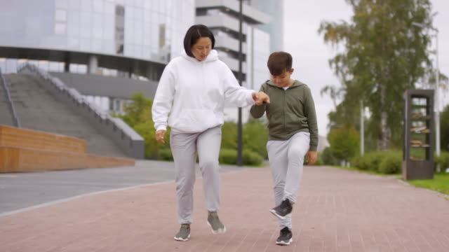 Madre-asiática-y-su-hijo-haciendo-ejercicio-al-aire-libre