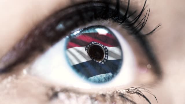 Woman-blue-eye-in-close-up-with-the-flag-of-Missouri-state-in-iris,-united-states-of-america-with-wind-motion.-video-concept