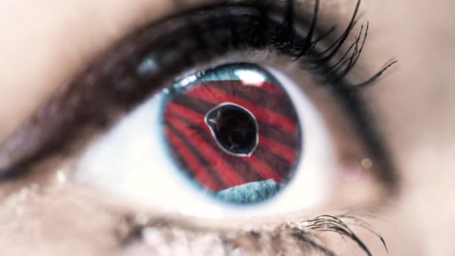 Woman-blue-eye-in-close-up-with-the-flag-of-Tennessee-state-in-iris,-united-states-of-america-with-wind-motion.-video-concept
