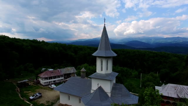 Christian-church-on-top-of-green-hill,-aerial-view,-camera-descending