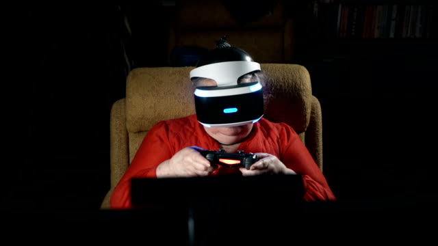 Ältere-Frau-im-VR-Kopfhörer-virtual-Reality-Spiel-vor-TV-Bildschirm
