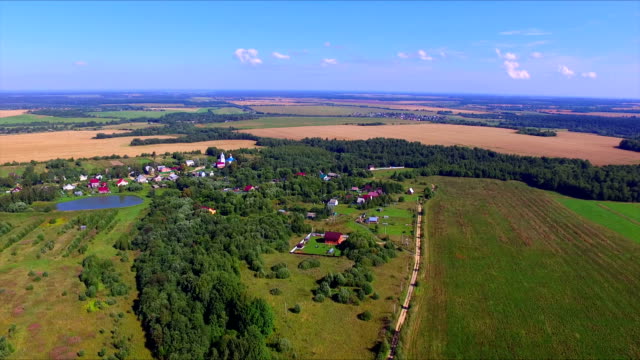 Flying-over-the-farmland-with-cultivated-fields-and-village
