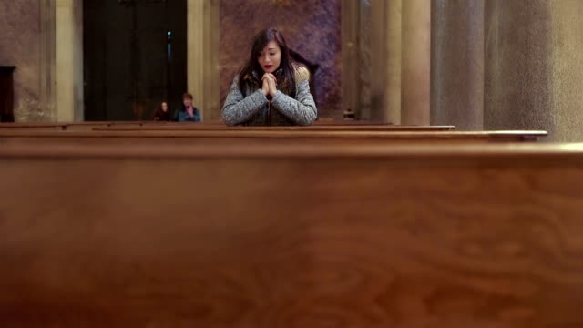 traurige-junge-Frau-betet-verzweifelt-in-der-Kirche