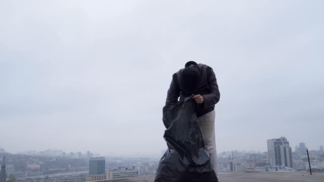 Obdachlose-sucht-etwas-in-den-Müllsack-im-städtischen-Hintergrund
