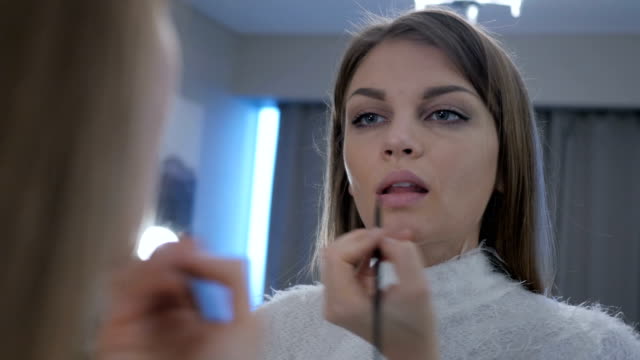 Schöne-Frau-im-Spiegel-Lippen-Lippenstift-aufsetzen