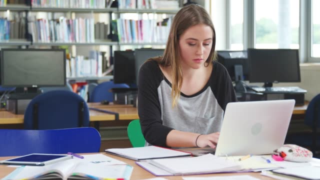 Weibliche-Schüler-arbeiten-am-Computer-In-der-Universitätsbibliothek