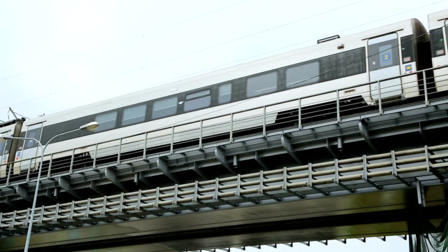 Modern-train-rushing-along-railway-bridge,-public-transportation,-urban-metro