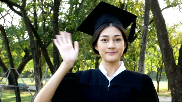 Jóvenes-estudiantes-mujer-Asia-usando-graduación-sombrero-y-vestido,-fondo-del-jardín,-mujer-con-el-concepto-de-graduación.