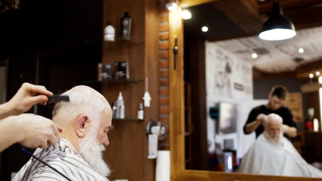 Peluquero-profesional-hace-peinado-moderno-fot-hombre-senior