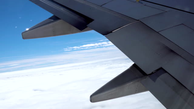 Detail-von-einem-Flugzeugflügel-fliegen-über-den-Wolken