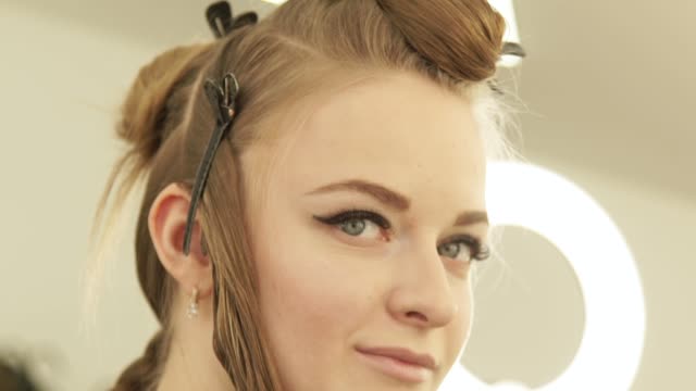 Beautiful-woman-with-clamp-for-fixing-long-hair-during-haircutting-in-hairdressing-salon.-Close-up-portrait-woman-hair-model-in-beauty-studio