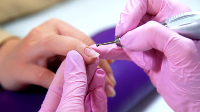 Kosmetikerin-sorgfältigen-und-genauen-entfernen-Nagelhaut-mit-polnischen-Maschine