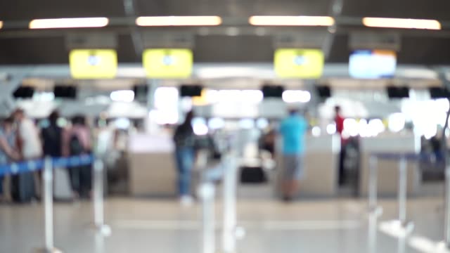 Blurred-footage-of-passengers-walking-to-check-in-counter-at-International-airport-terminal.-4K-video-with-defocused-effect.