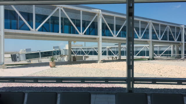 Modernen-Flughafen-Innenraum-mit-sitzen,-große-Fenster-und-Glas-Überführung-außerhalb