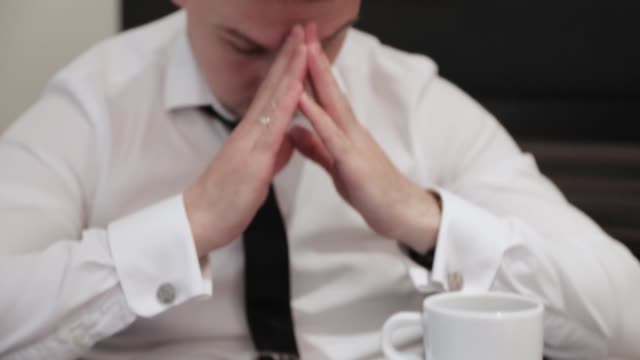 Portrait-of-businessman-regretting-about-something-with-hands-folded-praying