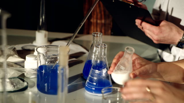 Científicos-examinar-líquidos-en-vasos.