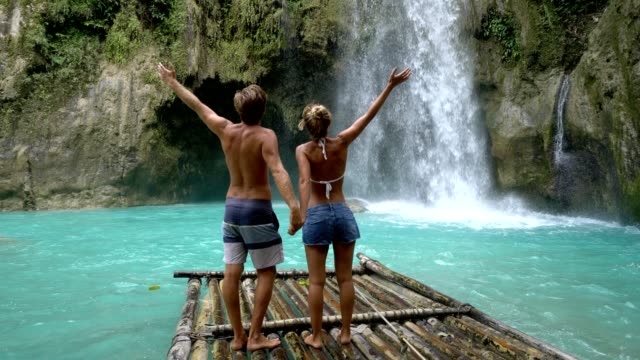 Junges-Paar-wird-zärtlich-an-wunderschönen-tropischen-Wasserfall-auf-den-Philippinen-Urlaub-und-Freiheit-genießen.-Reisekonzept-Liebe-Menschen