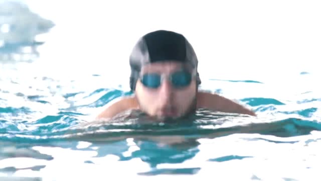 Hombre-discapacitado-nada-en-una-piscina-hacia-la-cámara