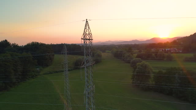 AERIAL:-Flying-close-to-a-metal-power-tower-providing-electricity-to-village.