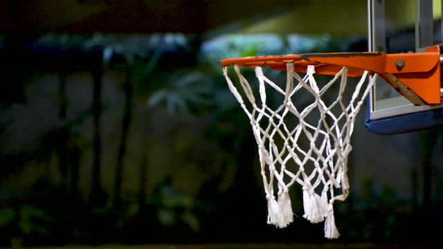 People-training-basketball-speed-dribble.-Basketball-net-close-up.-Flat-plane.-Side-view