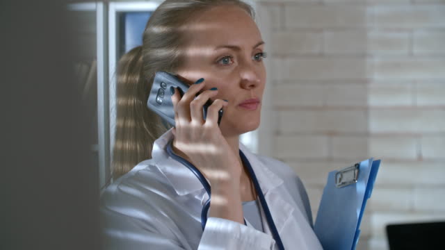 Médico-de-la-mujer-hablando-por-teléfono