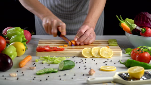 Chef-is-cutting-vegetables-in-the-kitchen,-slicing-carrot