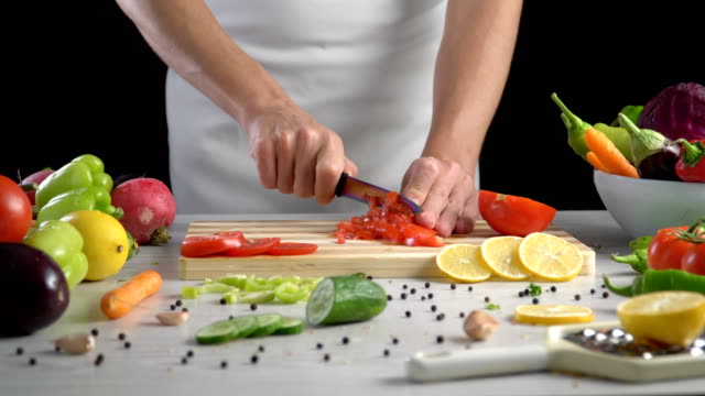 Chef-is-cutting-vegetables-in-the-kitchen,-slicing-tomato