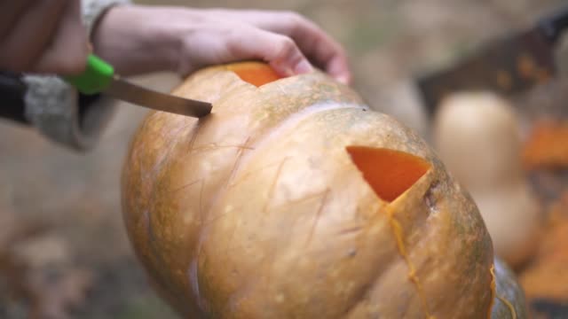 Halloween.-Male-hands-carve-a-halloween-pumpkin.