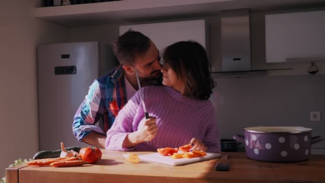Smiling-girlfriend-threatening-her-boyfriend-with-knife-in-the-kitchen
