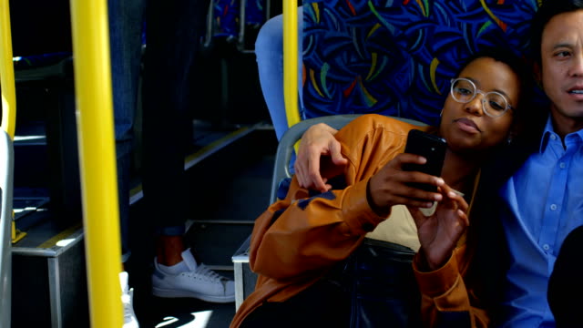 Pareja-usando-el-teléfono-móvil-mientras-viajas-en-autobús-4k