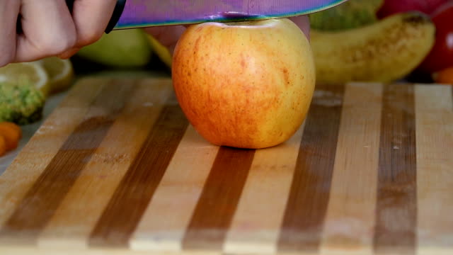 Man-is-cutting-an-apple-on-cutting-board-in-slow-motion