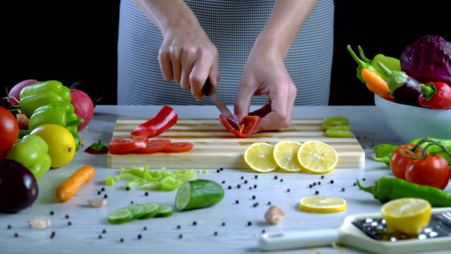 El-hombre-es-vegetales-de-corte-en-la-cocina,-cortar-el-pimiento-rojo