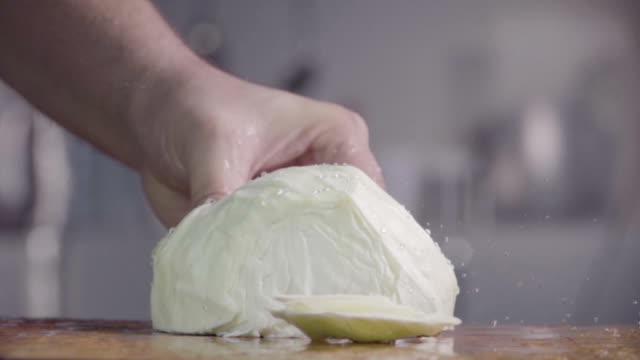Cutting-cabbage-with-kitchen-ax-on-the-wood.-Slow-motion