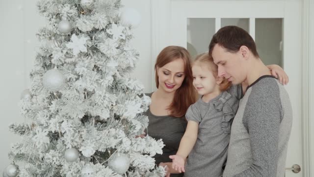 Die-Familie-steht-in-der-Nähe-der-Weihnachtsbaum,-lachen,-reden-und-Spielzeug-zu-berühren,-während-des-Wartens-auf-Weihnachten