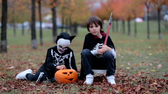 Kinder-Spaß-mit-Halloween-geschnitzten-Kürbis-in-einem-Park,-gruselige-Kostüme-tragen-und-spielen-mit-Spielzeug
