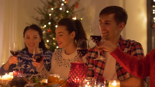 Glückliche-Freunde-trinken-Rotwein-am-Weihnachtsessen
