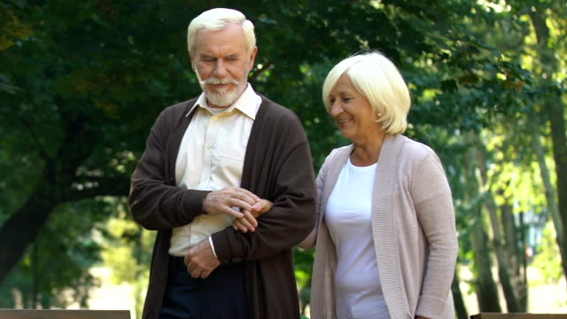 Elder-couple-hugging-and-walking-at-summer-park,-enjoying-pastime-together