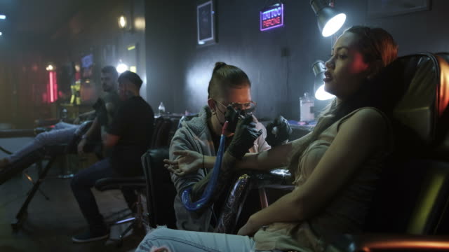 Man-Woman-Getting-Tattoo-in-Beauty-Salon-With-Artists-Working