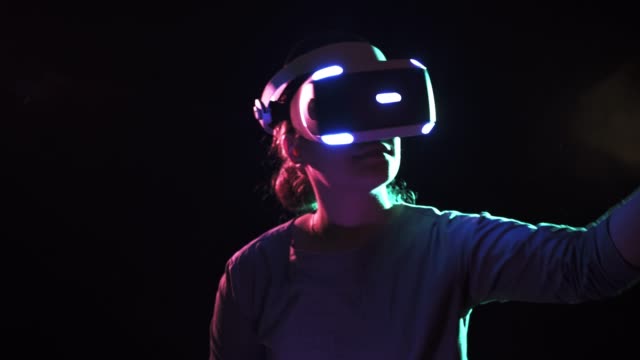 Girl-in-VR-Headset-bewegt-moderne-Bewegungsregler-in-Händen